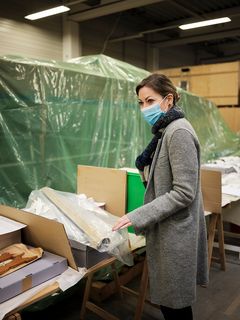 In einem Lagerraum des Deutschen Schifffahrtsmuseums holt die Provenienzforscherin Kathrin Kleibl Untersuchungsobjekte aus Kartons heraus.