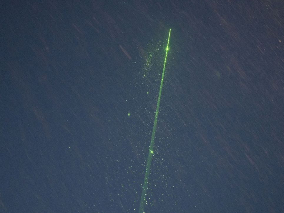 Grüner Lichtstreifen vor blau-grauem Hintergrund.