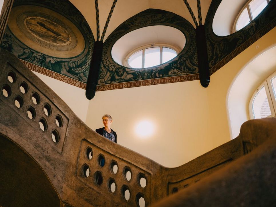 Brigitte Finke steht in einem Treppenhaus