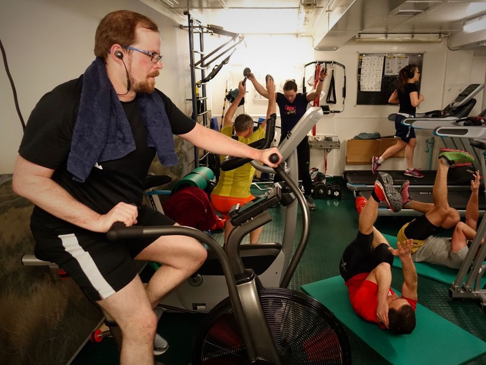 Personen machen Sport an Fitnessgeräten.