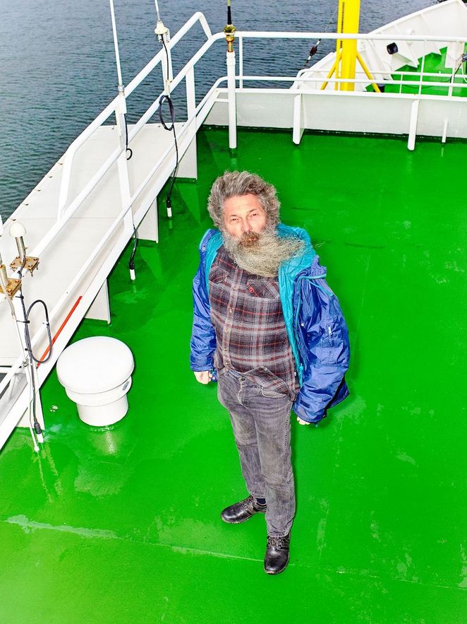 Ulrich Bathmann steht an Deck eines Schiffs auf knallgrünem Boden.