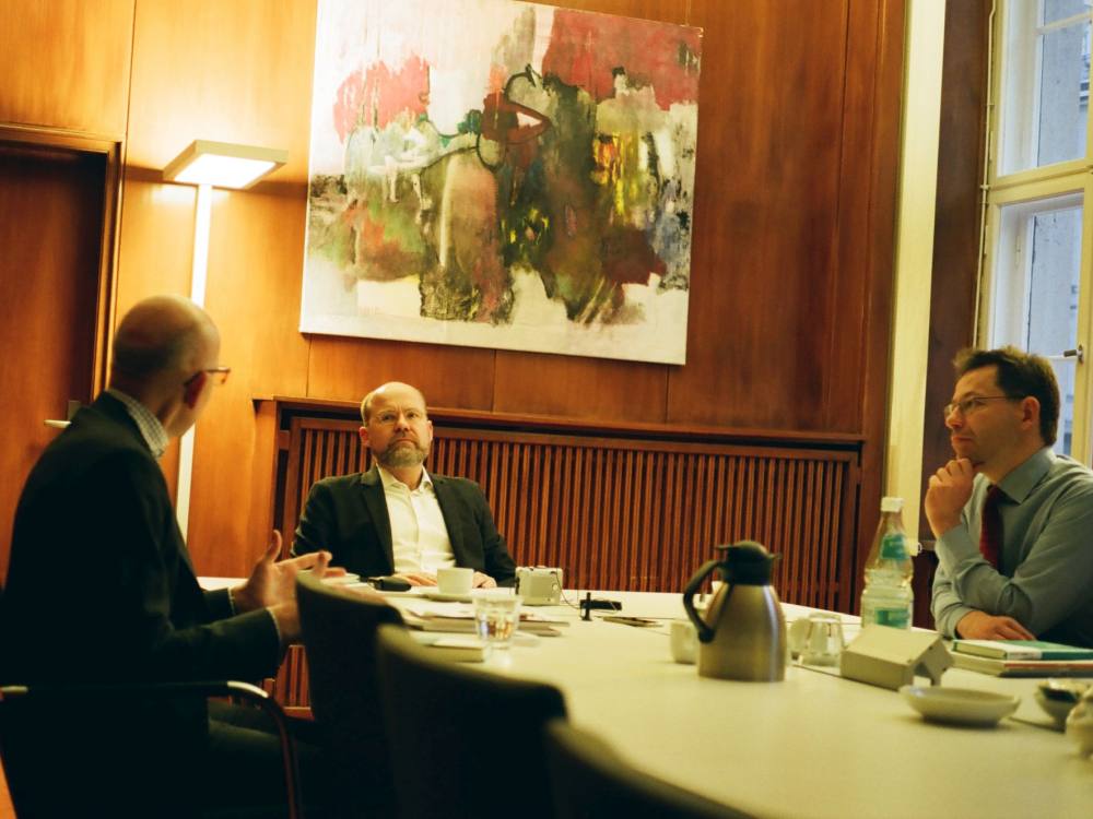 Der Interviewer Michael Bauchmüller mit Heinz Bude und Georg Feulner an einem Tisch im Gespräch.