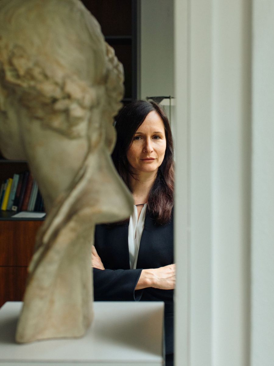 Alexandra W. Busch hinter einer Steinskulptur.