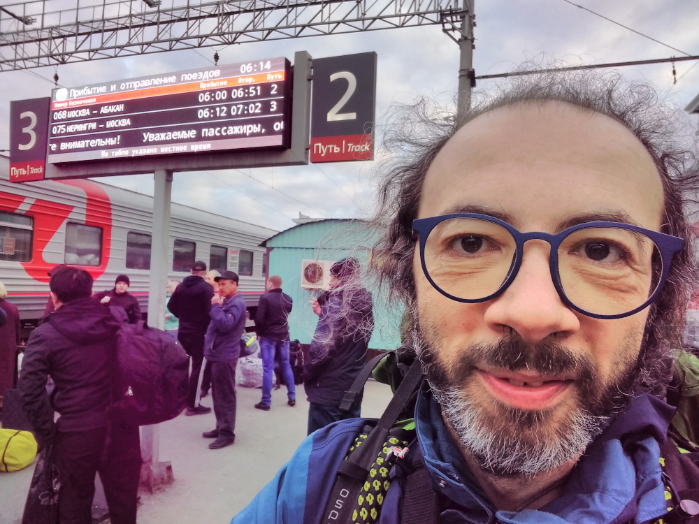 Gianluca Grimalda mit Rucksack in einer belebten Bahnhofshalle.