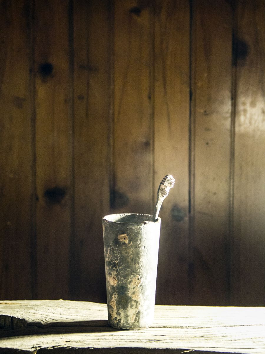 Sehr alt aussehende Zahnbürste in einem Becher.