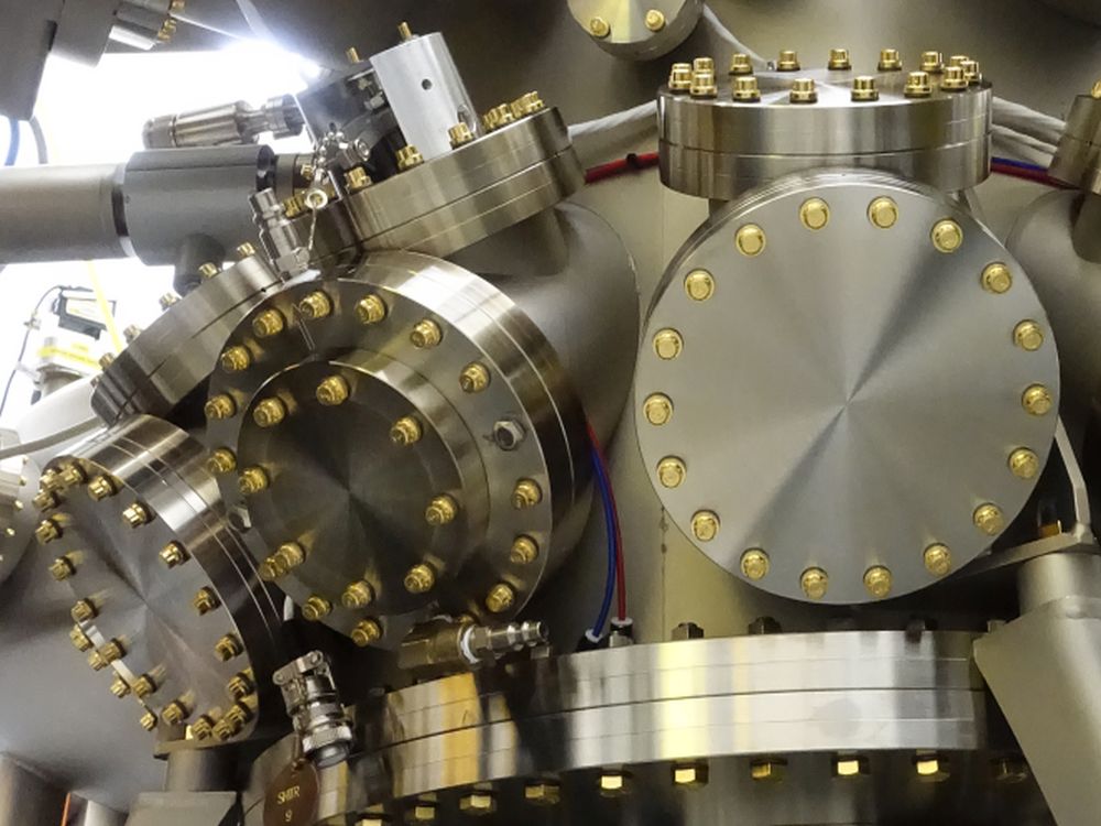 Eine Moleklarstrahlepitaxieanlage mit vielen runden Scheiben aus glänzendem Metall.