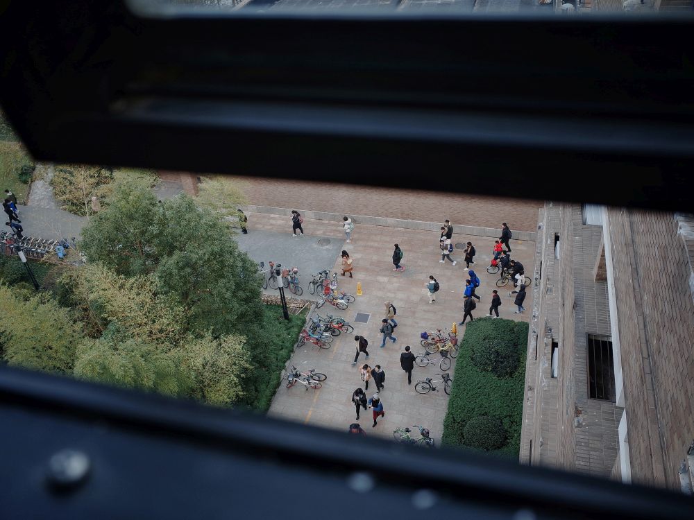 Blick von oben auf Personen vor einem Gebäude