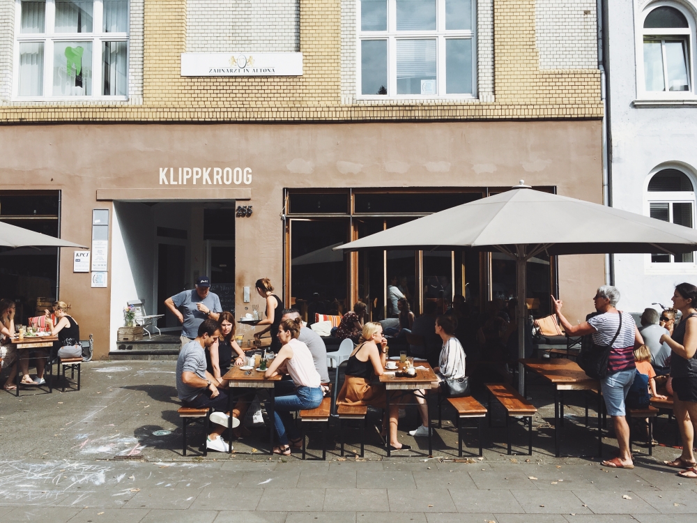 Gäste sitzen im Außenbereich eines Cafés.